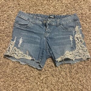 Distressed denim shorts with lace detailing